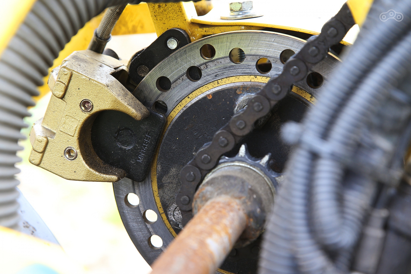 Тормозной диск всего один, расположен он на трансмиссии, благодаря чему замедляются оба колеса одновременно